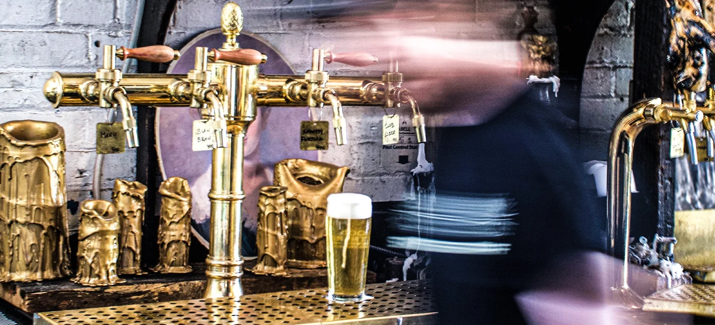 Brass beer taps and a freshly poured glass at Blood Brothers Brewing