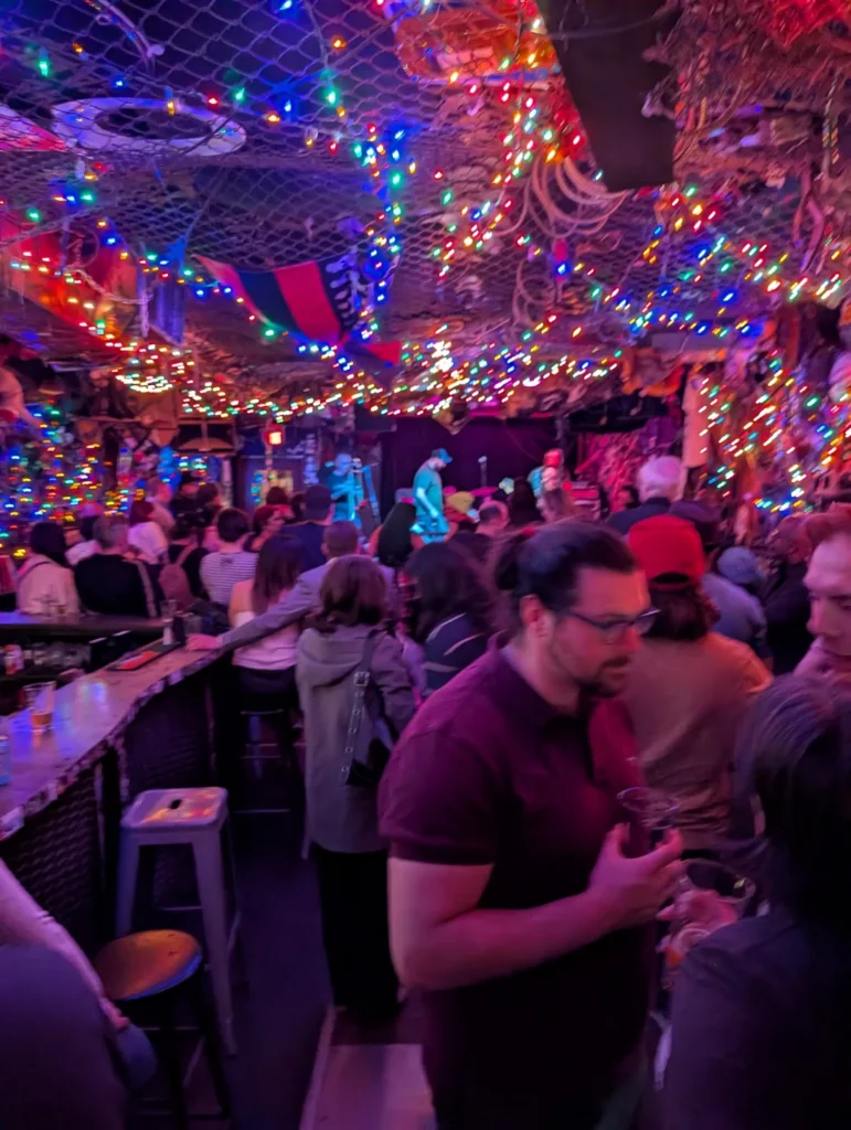 A crowd near the stage under coloured lights at Bovine Sex Club