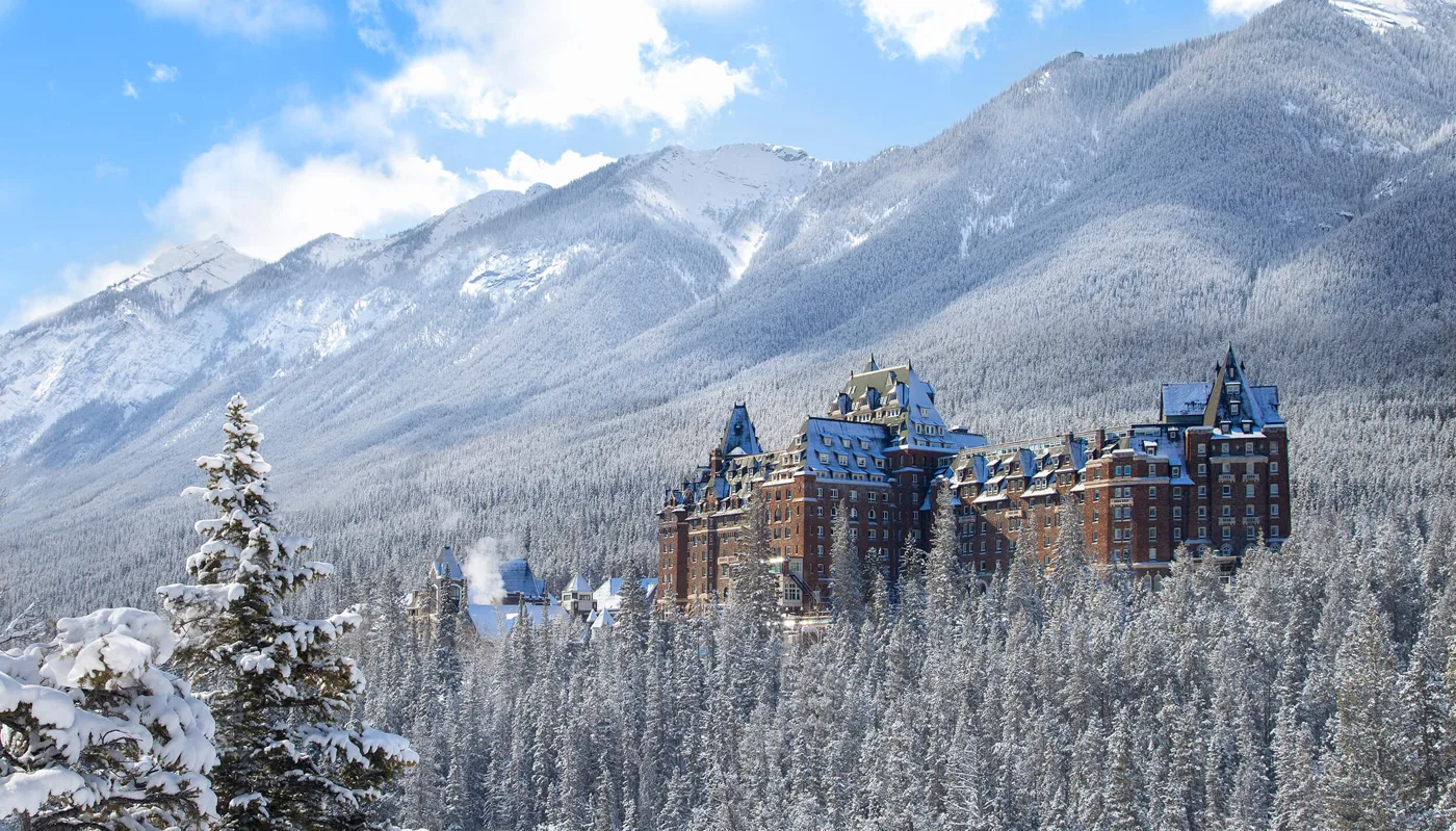 Fairmont Banff Springs surrounded by snow-covered trees and mountains