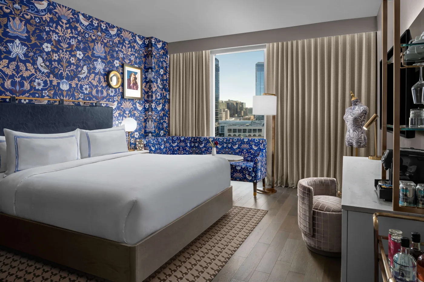 Blue floral walls behind a king bed at the Dorian in Calgary