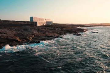 Fogo Island Inn on the rocky Atlantic shoreline in warm evening light