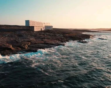 Fogo Island Inn on the rocky Atlantic shoreline in warm evening light