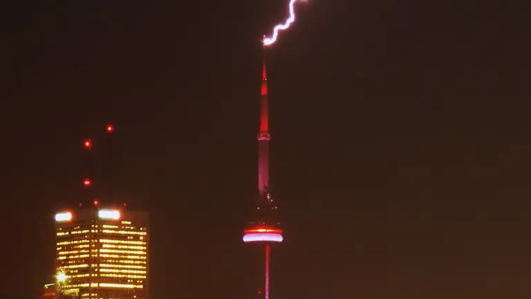 Bright lightning bolt striking the CN Tower during a Toronto storm