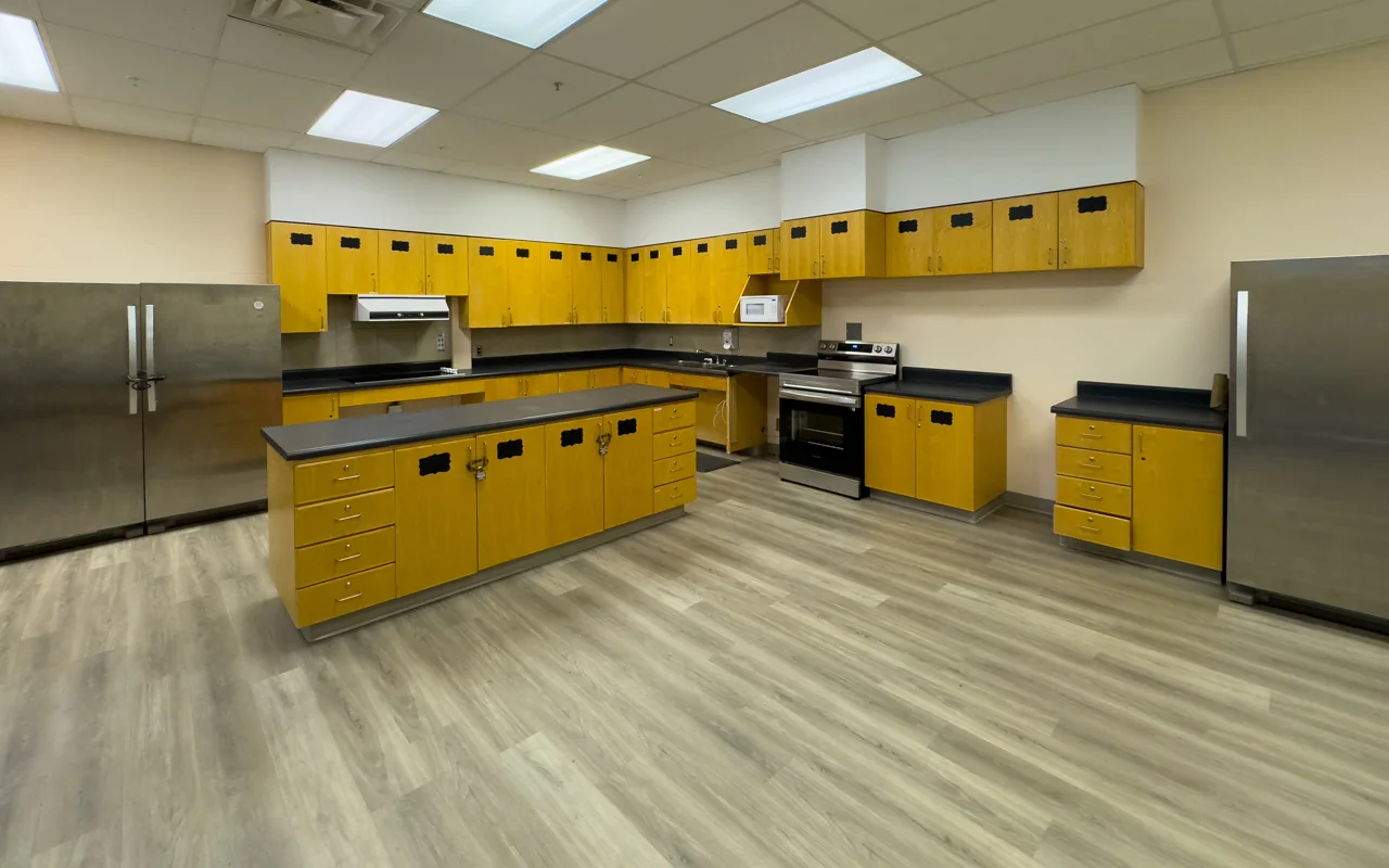 A yellow kitchen with counters, a stove and a central worktable at Edithvale.