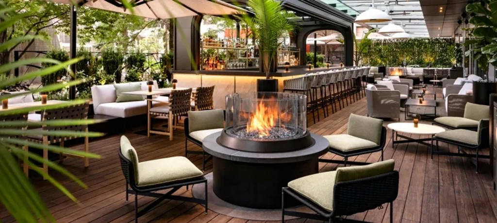 Tables, lounge chairs, plants and a glass-sided fire feature on the EPOCH terrace