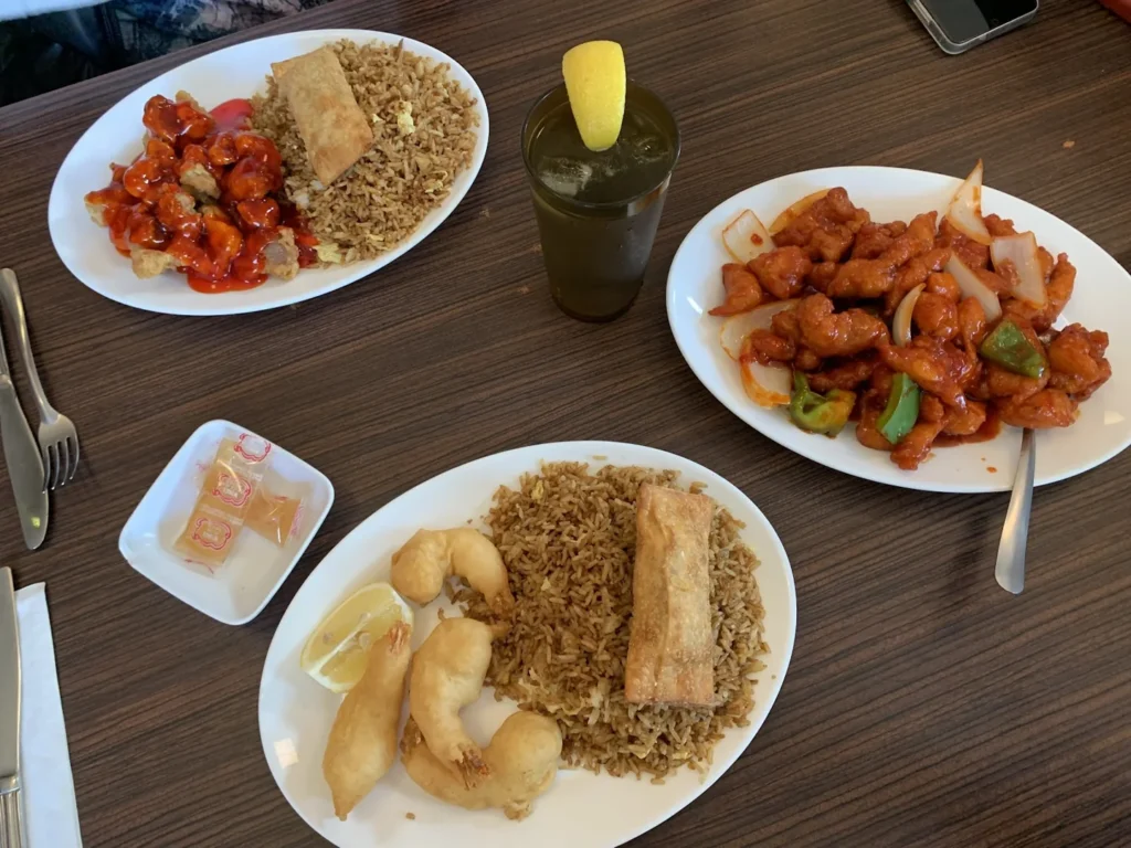 Fried rice, egg rolls and sauced dishes on a Garden Gate table