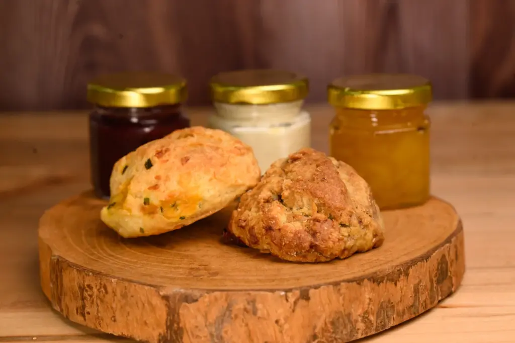 Two scones served with jars of preserves and cream from High Societea