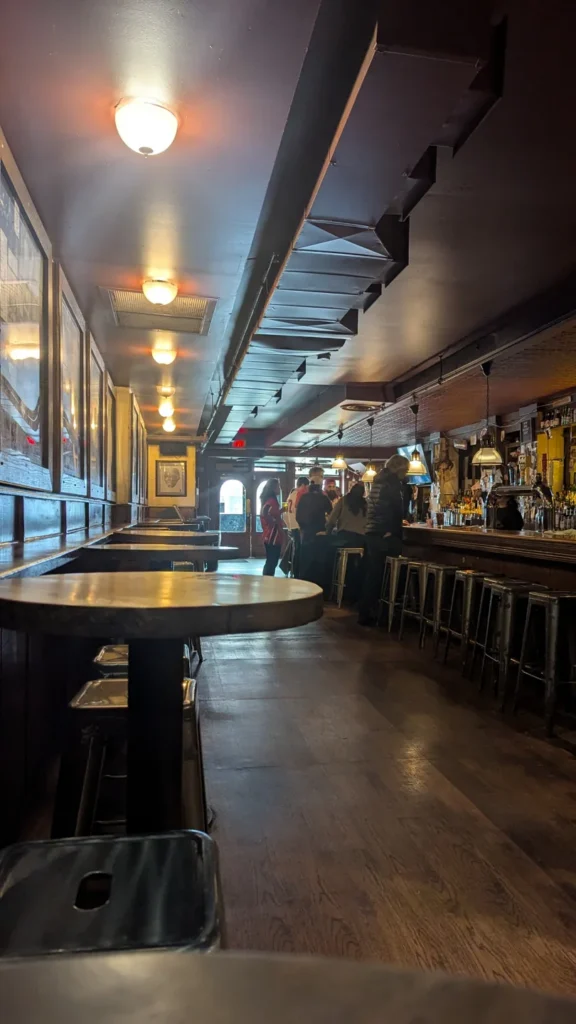 Tables and high stools along the long front bar at Horseshoe Tavern