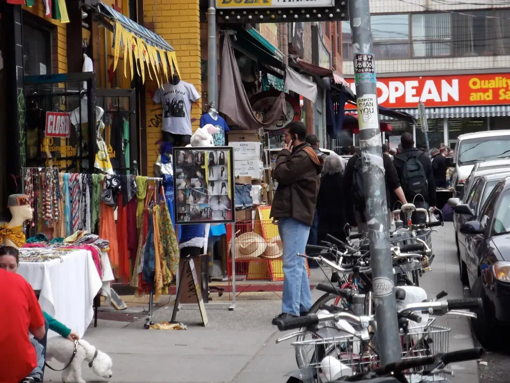 People walking past shops and produce stands in Kensington Market