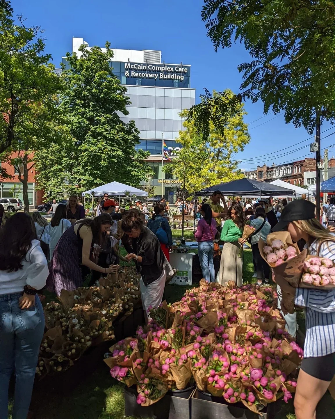 Shoppers browsing outdoor flower stalls at the CAMH market site