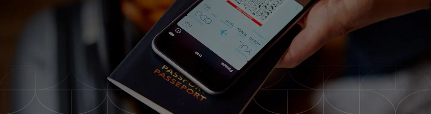 A hand holds a phone above a Canadian passport