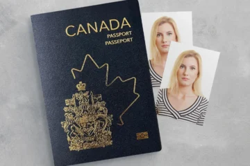 A Canadian passport and two printed photographs of a woman on a grey surface