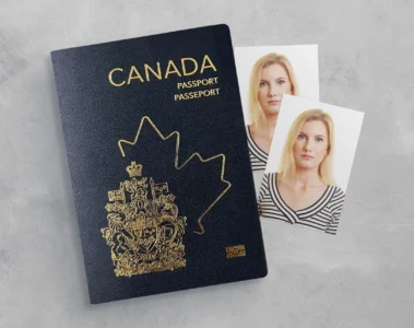 A Canadian passport and two printed photographs of a woman on a grey surface