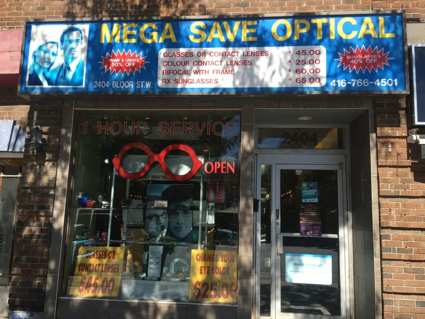 Mega Save Optical’s old storefront sign showing historic prices and the old 2404 address