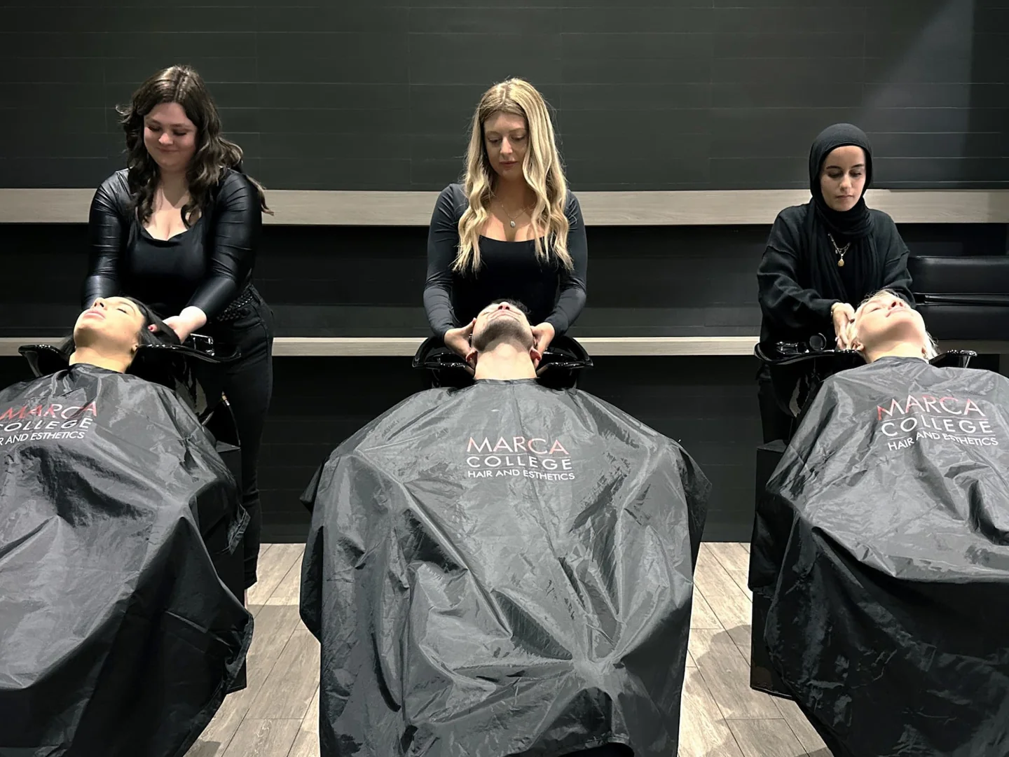 Students practising hair styling on mannequin heads at Marca College.