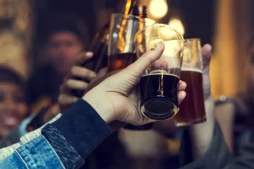 Hands raising beer glasses in a pub photograph supplied by The Rhino