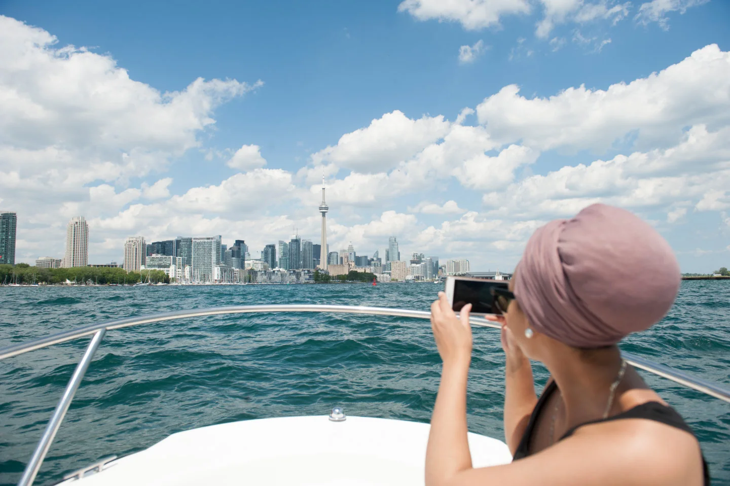 A visitor photographing Toronto from a boat on Lake Ontario