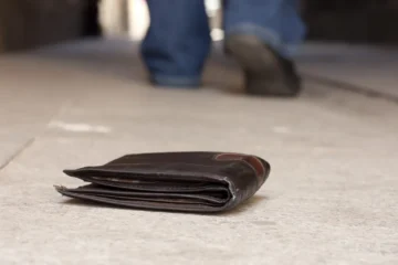 A wallet on the ground as a person walks away