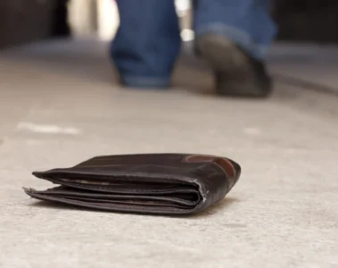 A wallet on the ground as a person walks away