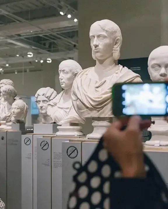 A visitor photographing sculptures at ROM