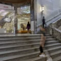 Visitors passing a dinosaur skull display beside a ROM staircase