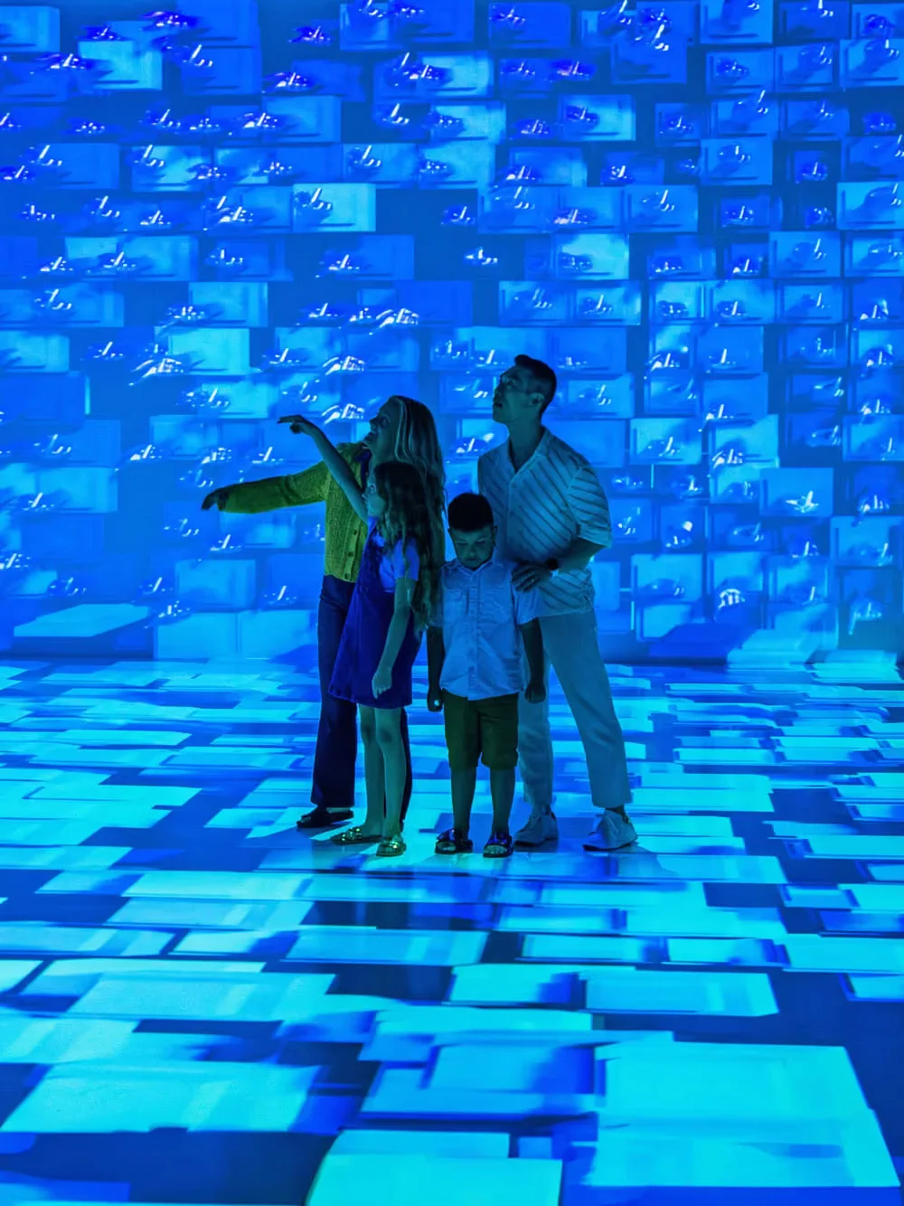 Two visitors inside a blue projection room at Arcadia Earth