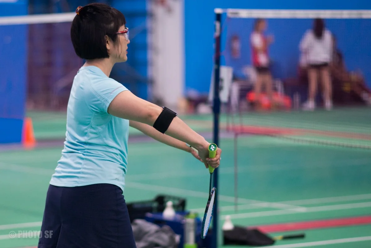 A badminton player preparing to return the shuttle at Epic Sports