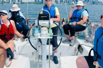 Sailing participants with Toronto buildings across the water