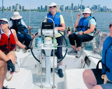 Sailing participants with Toronto buildings across the water
