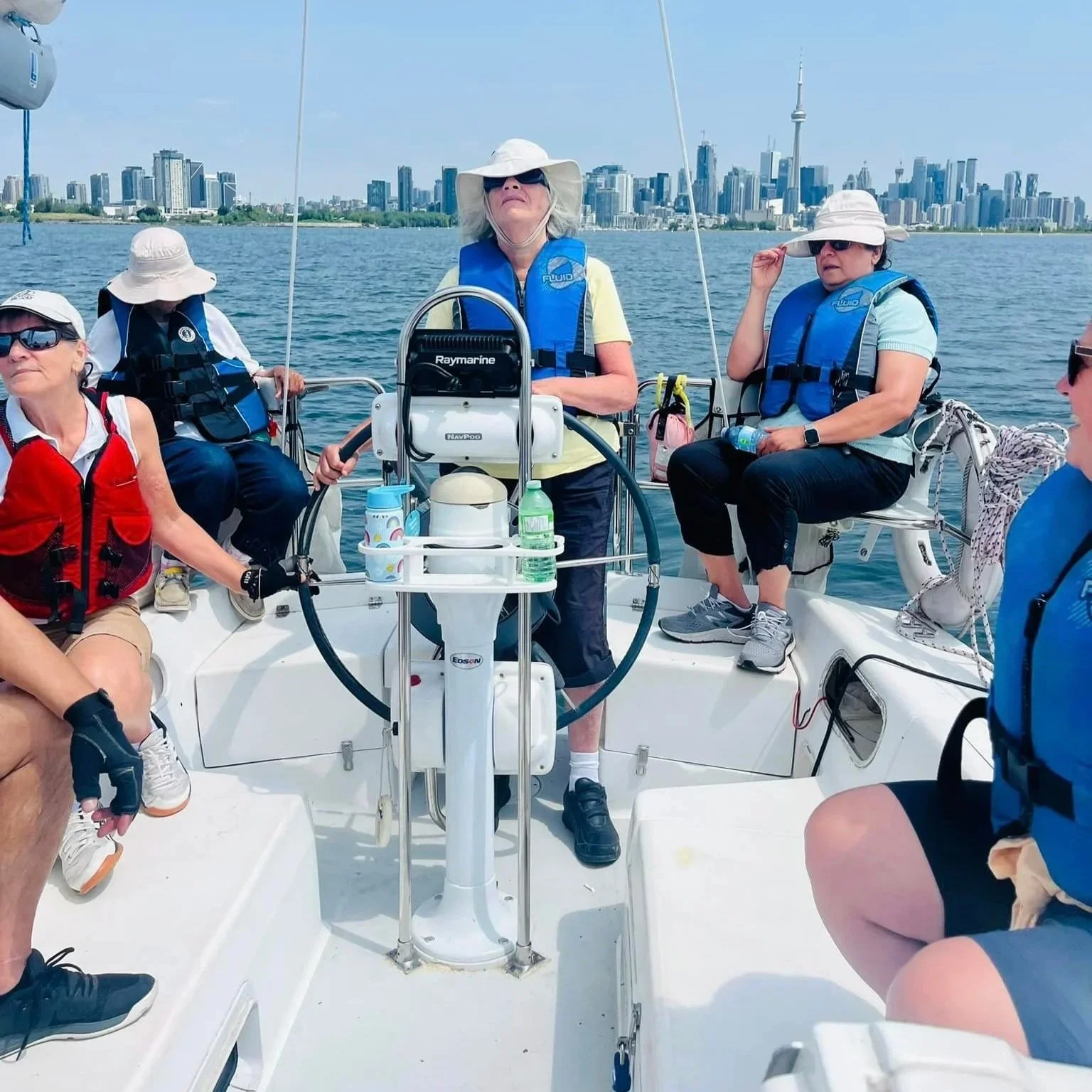Sailing participants with Toronto buildings across the water