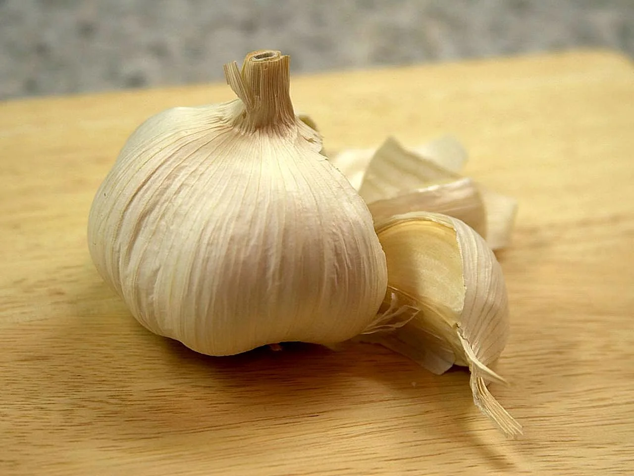 A whole garlic bulb beside separate cloves