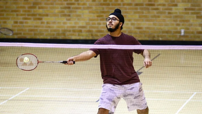 A player preparing a badminton shot at TMU