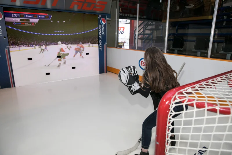 A visitor playing goalie at a Hockey Hall of Fame interactive exhibit