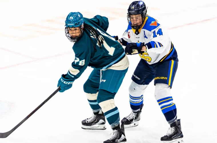 Lexie Adzija and Renata Fast competing for the puck