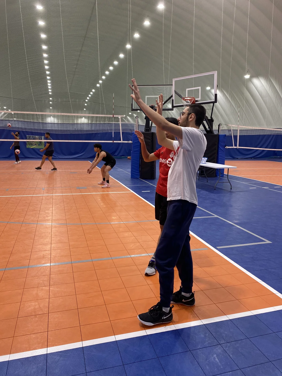 Two players practising volleyball in a gym