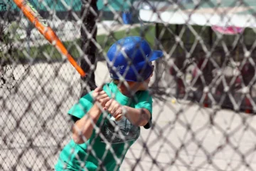 A young batter swings inside an outdoor cage at Pickering Playing Fields