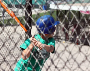 A young batter swings inside an outdoor cage at Pickering Playing Fields