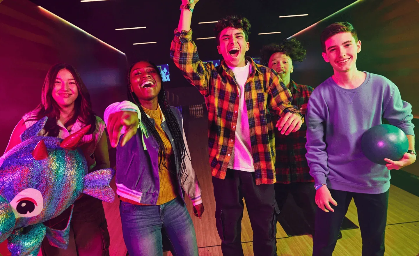 Friends celebrate at a bowling lane in Playdium promotional photography