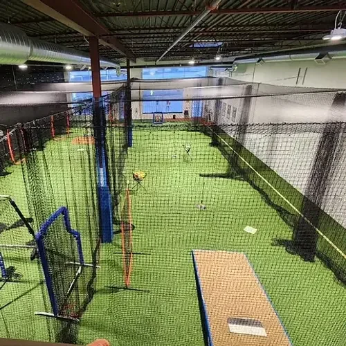 Green indoor batting lanes and nets at Total Baseball Training Centre