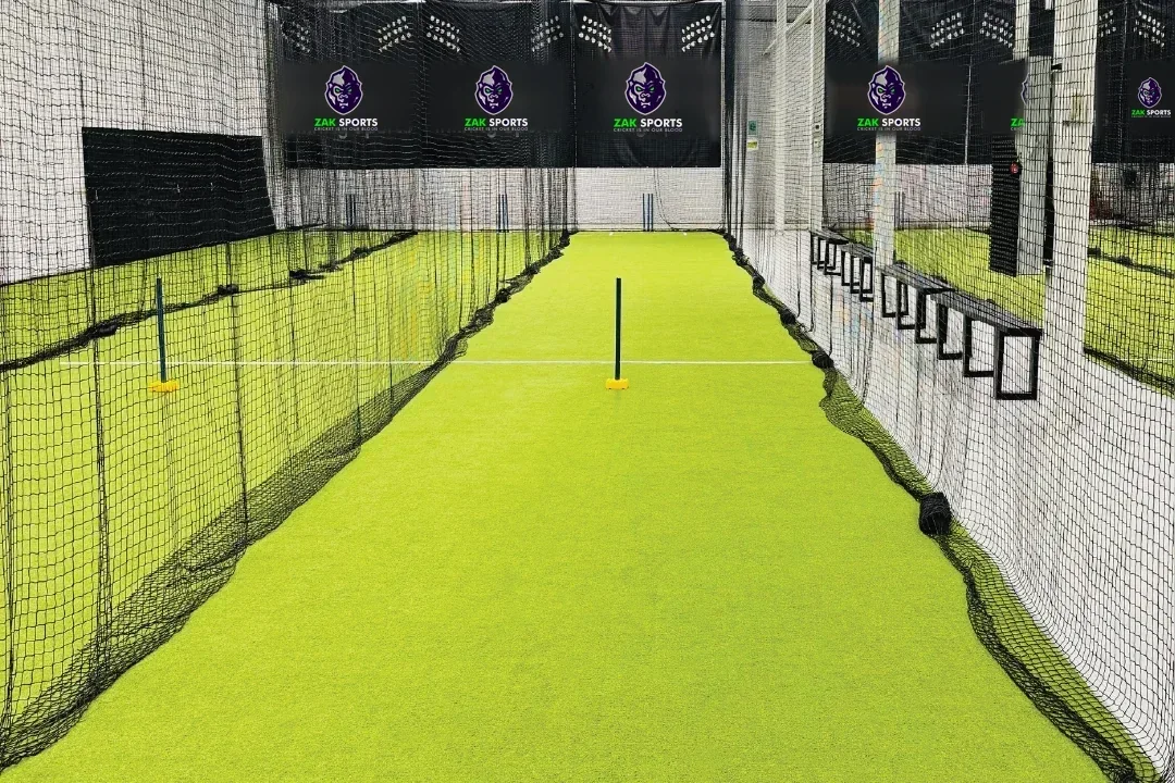 Netted cricket practice lanes with a Zak Sports sign