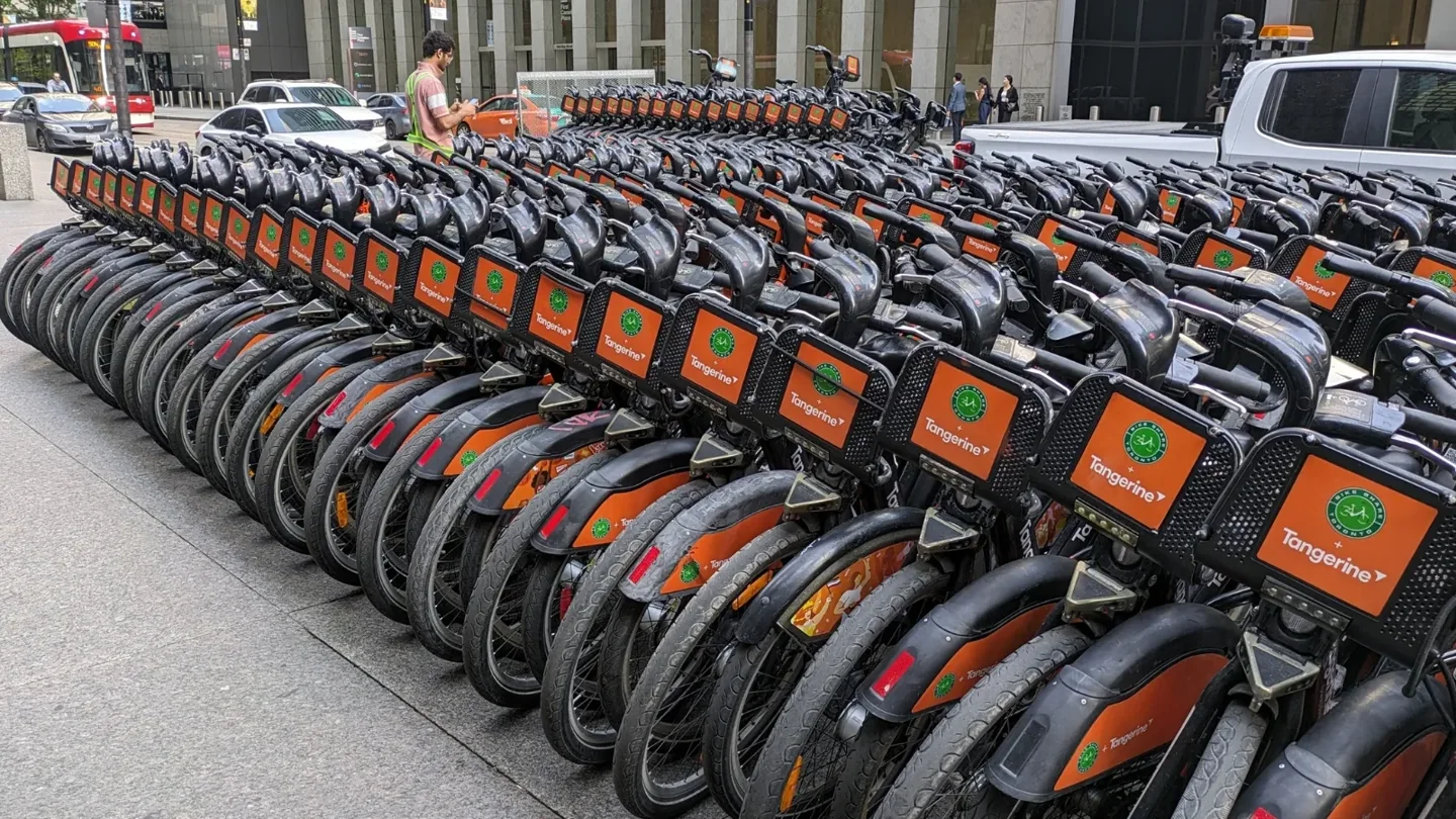 Rows of Bike Share bicycles and a worker at the Union Station valet area