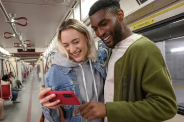 Two riders look at a phone inside a TTC subway train