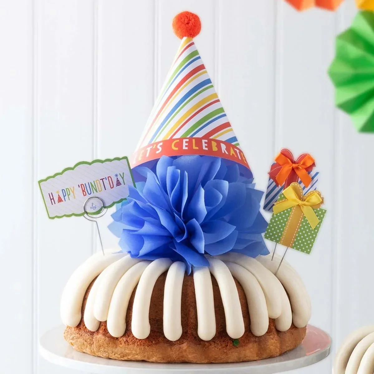 A Bundt cake with piped cream-cheese frosting and birthday decorations