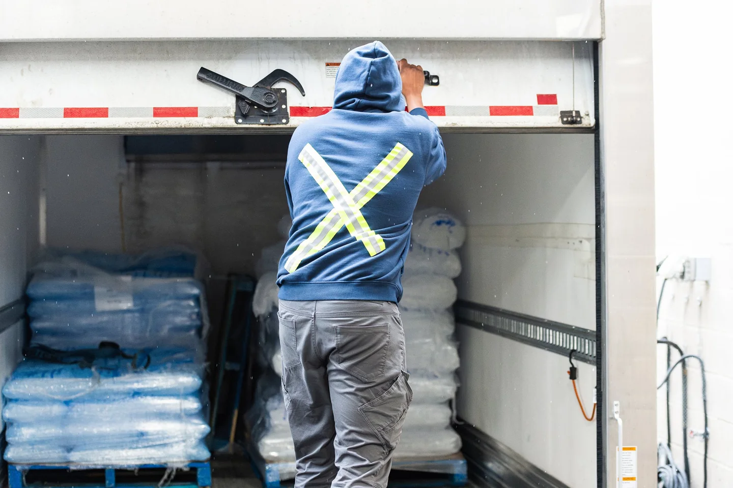 An Iceman worker loads bagged ice into a delivery truck