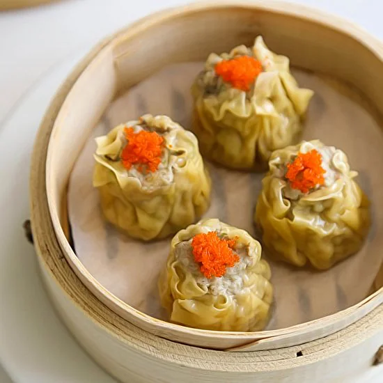 Four siu mai dumplings in a bamboo steamer in Dim Sum King’s menu photograph