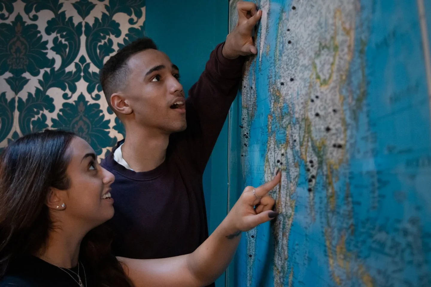 Two players inspect a puzzle on a patterned wall in Captive’s official gallery