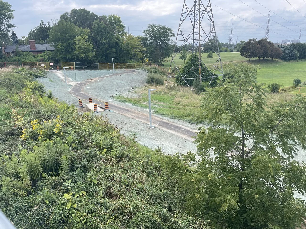 The curved busway connection near Kennedy seen through trees before opening