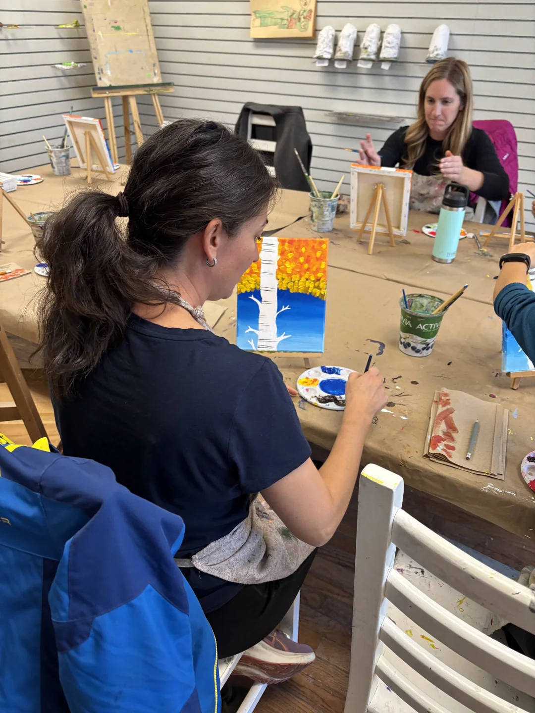 Children work on paintings around an art studio table