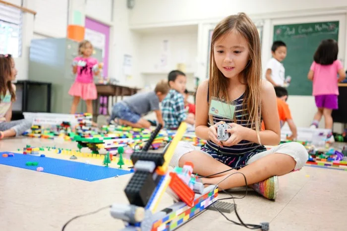 A child builds with colourful LEGO pieces indoors