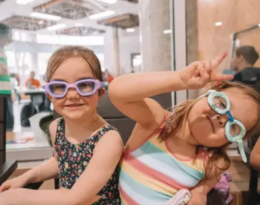 Two smiling children wear swimming goggles at Variety Village